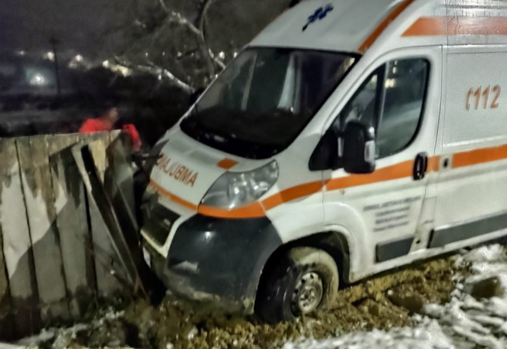 O ambulanță cu o pacientă la bord, a derapat pe zăpadă și s-a oprit într-un gard