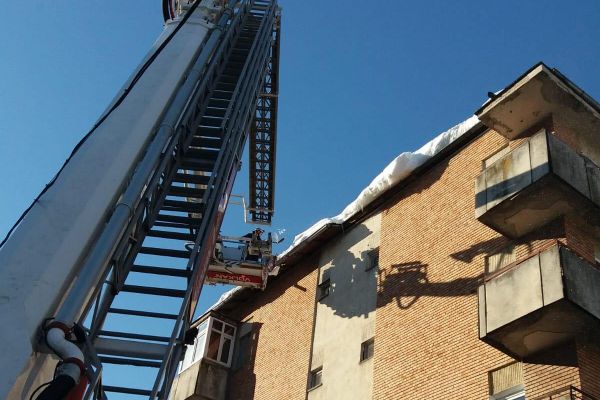 Pompierii îndepărtează gheața de pe acoperișul blocurilor